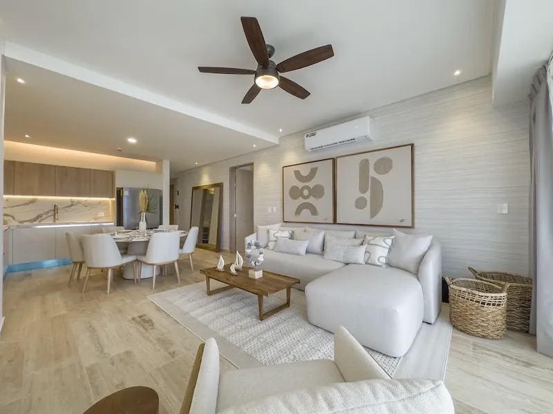 Sala de Sole BLU con sofá modular blanco, comedor al fondo y cocina integrada